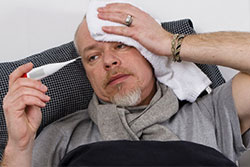 Man with flu, taking his temerature Man with flu, taking his temerature